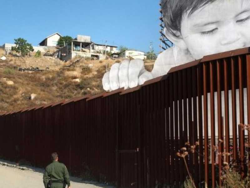 Installazione dell'artista francese JR sul muro che divide il Messico dagli Stati Uniti (foto LaPresse)