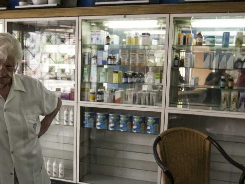 Una farmacista davanti al bancone dei medicinali. Il paese vive una crisi di rifornimenti di medicinali senza precedenti (foto LaPresse)