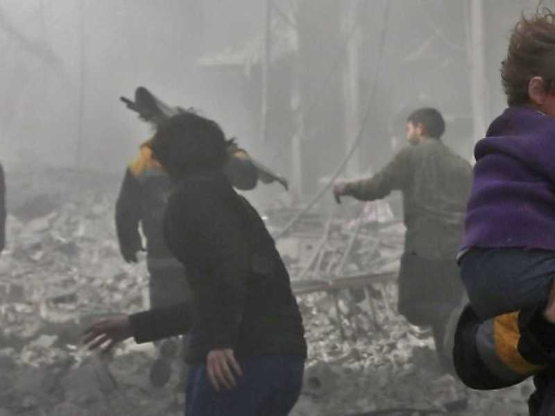 Uomini in fuga durante un bombardamento nella citt&agrave; ribelle di Hamouria, nella regione di Ghouta il 19 febbraio. Foto LaPresse