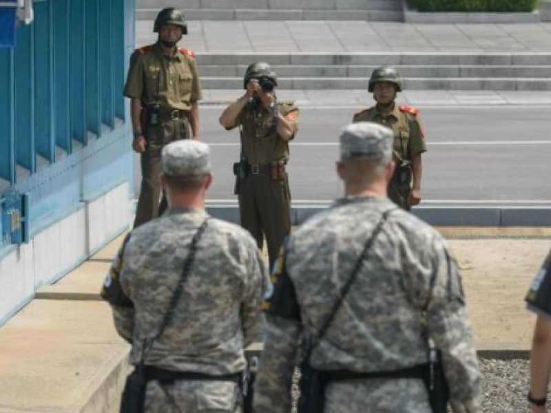 Soldati nordcoreani fotografano i soldati sudcoreani e americani al confine tra le due Coree (foto LaPresse)
