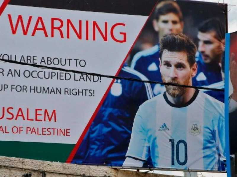 Un manifesto affisso a Hebron, in cui si denuncia l'amichevole tra Argentina e Israele in programma a Gerusalemme (foto LaPresse)