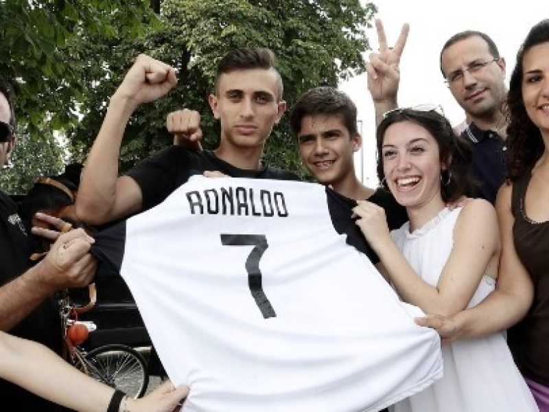 Tifosi della Juve posano con la nuova maglia di Cristiano Ronaldo (foto LaPresse)