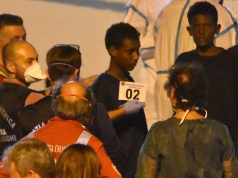 Un gruppo di migranti sbarca dalla Diciotti a Catania (foto LaPresse)