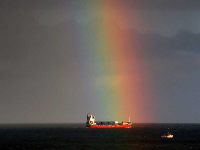 Una nave mercantile passa accanto a un arcobaleno sul Mare del Nord al largo delle coste di Whitley Bay, Tyne e Wear (foto LaPresse)