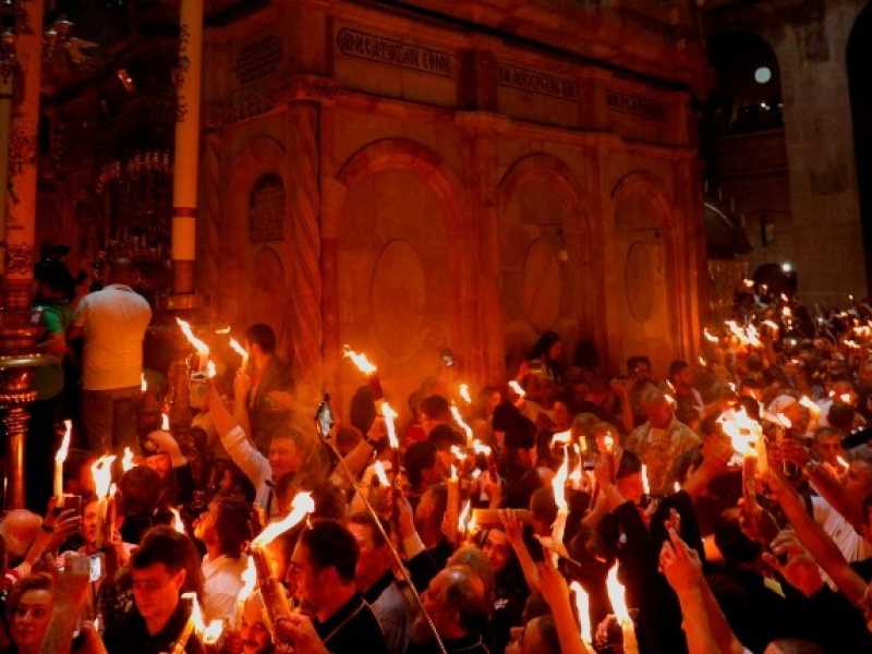 I fedeli cristiani ortodossi tengono candele accese dal "Fuoco Santo" mentre si riuniscono nella Chiesa del Santo Sepolcro nella Citt&agrave; Vecchia di Gerusalemme (foto LaPresse)