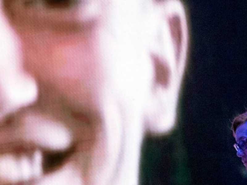 La sorella di Stefano Cucchi, Ilaria, e sullo sfondo il volto del fratello defunto (Foto LaPresse)