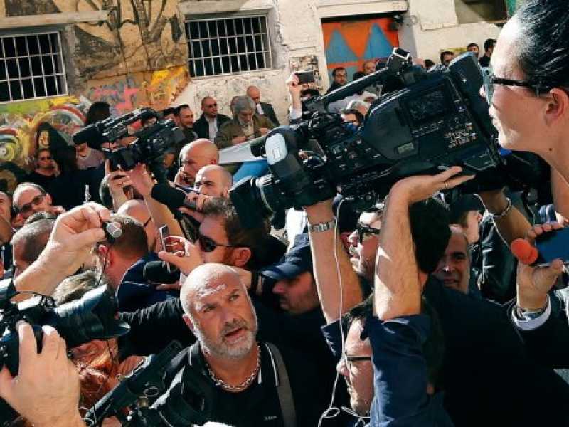 Matteo Salvini, a sinistra, circondato dai giornalisti nel quartiere di San Lorenzo a Roma (foto LaPresse) 