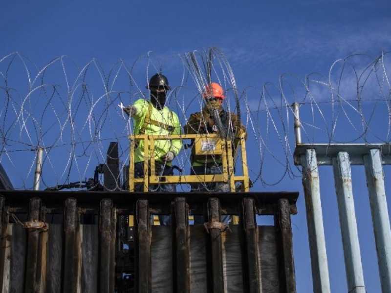 A Tijuana viene messo il filo spinato sul muro che divide il Messico dall'America (foto LaPresse)