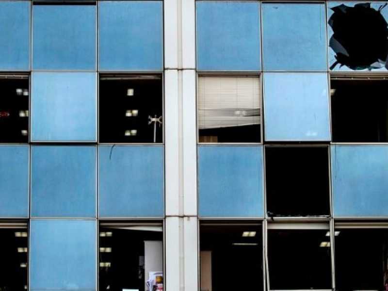 I vetri dell'edificio della televisione greca distrutti dall'esplosione (foto LaPresse)