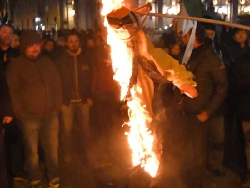 Il manichino bruciato in piazza durante la protesta degli Ncc. Foto LaPresse