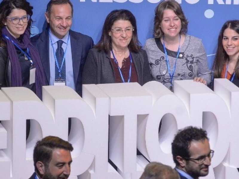 I militanti del M5s posano dietro la scritta del reddito di cittadinanza (Foto Imagoeconomica)