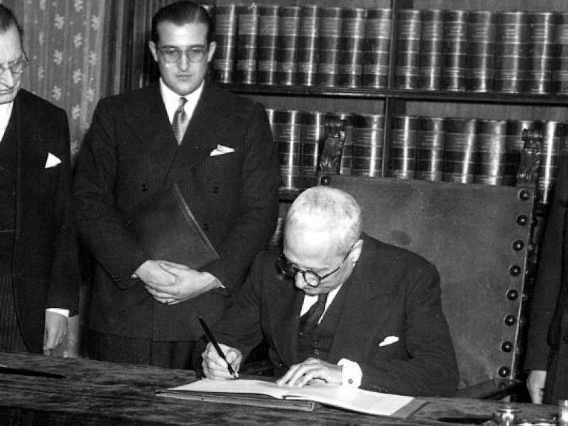 Il presidente della Repubblica, Enrico De Nicola, firma la Costituzione. Ultimo sinistra, Alcide De Gasperi  (foto LaPresse)
