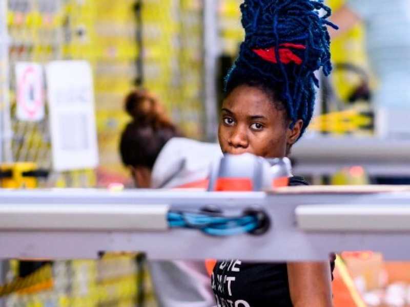 Una donna che lavora nel centro di distribuzione Amazon di Staten Island, NY (foto LaPresse)