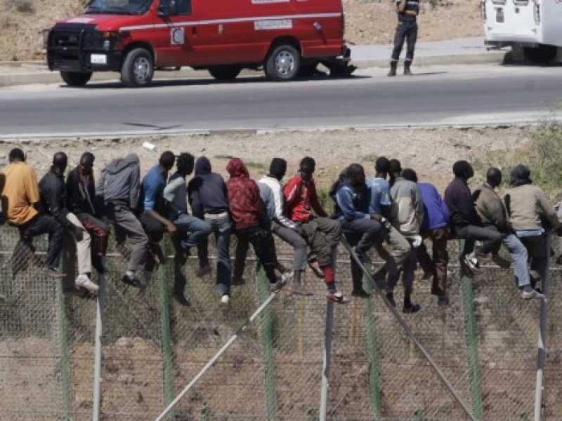Alcuni migranti cercano di oltrepassare le barriere a Melilla, l'enclave spagnola in Nord Africa (Foto LaPresse)