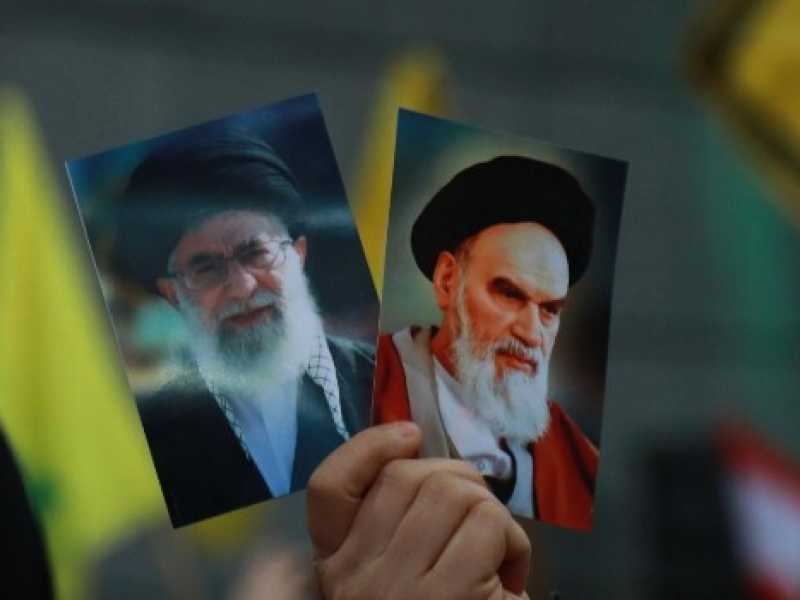 Alcuni manifestanti di Hezbollah sollevano le immagini dell'Ayatollah Khomeini (Foto LaPresse)