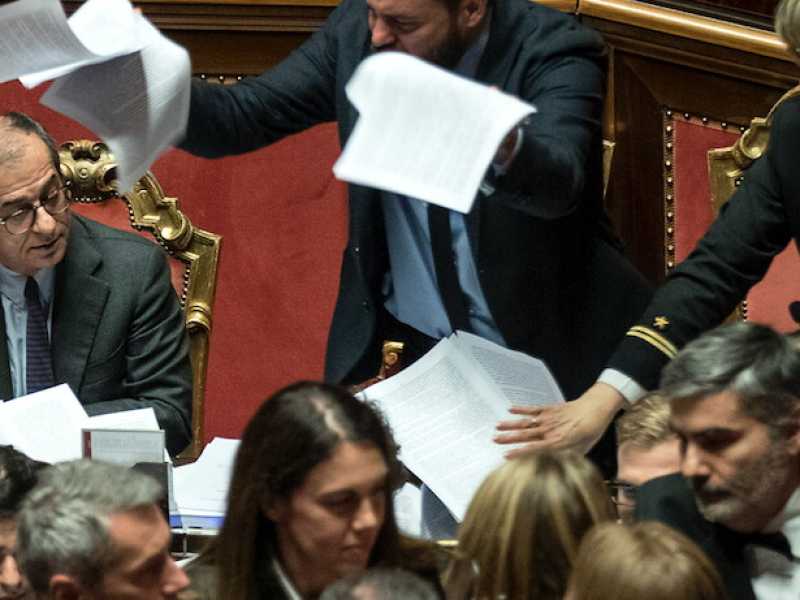 Senatori del Pd lanciano le pagine della legge di Bilancio verso i banchi del governo (foto LaPresse)