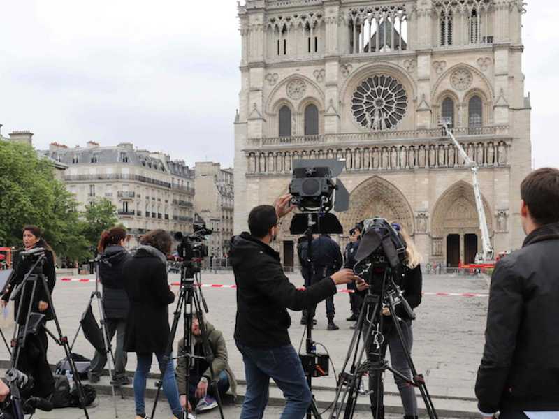 I giornalisti davanti a Notre-Dame il giorno dopo l'incendio della cattedrale. Foto LaPresse