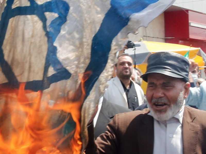 Alcuni manifestanti iraniani bruciano una bandiera di Israele (Foto LaPresse)