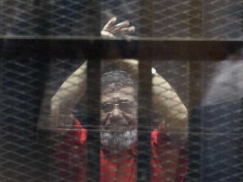 Un giovane palestinese scatta un selfie a Gaza davanti a un poster commemorativo dell&rsquo;ex presidente egiziano Mohamed Morsi, deceduto il 17 giugno (Foto LaPresse)