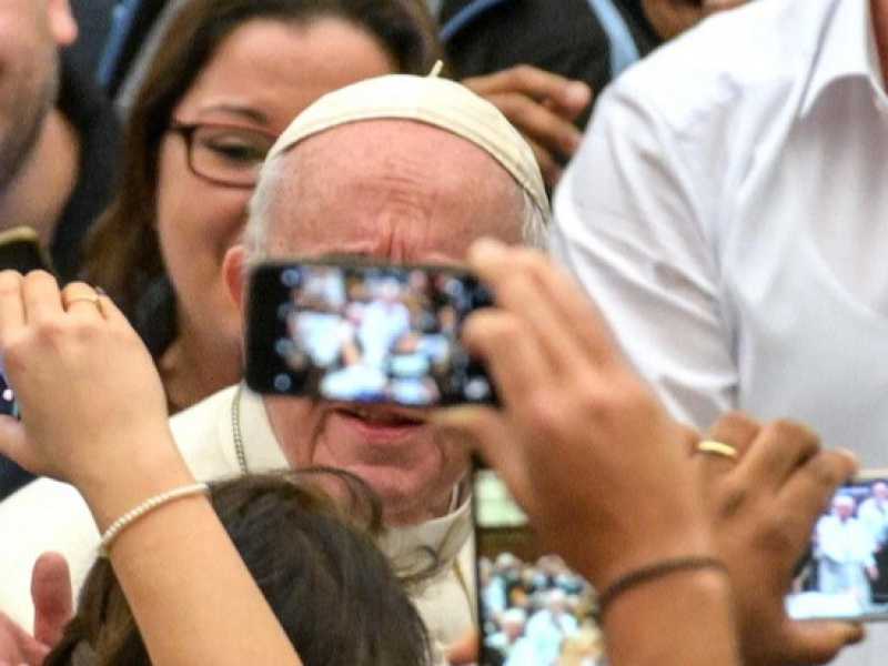 Fedeli fotografano Papa Francesco durante un'udienza generale (foto LaPresse)