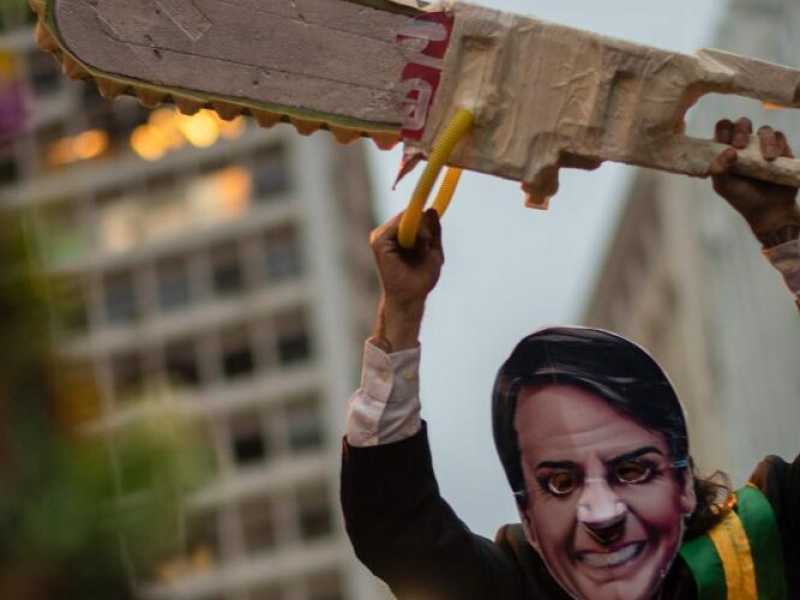 A Rio de Janeiro, un manifestante travestito da Bolsonaro protesta contro le politiche ambientali del governo (foto LaPresse)