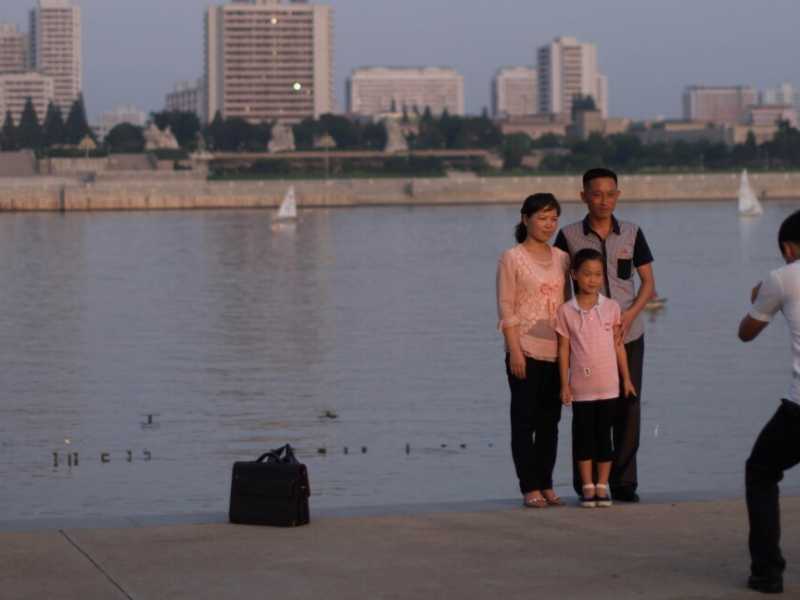 Una famiglia posa nei pressi della riva del fiume Taedong, a Pyongyang (foto LaPresse)