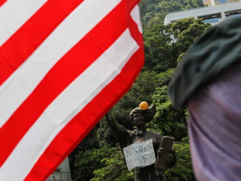 I manifestanti di Hong Kong si rifanno alla bandiera a stelle e strisce, presa a simbolo di valori universali, mentre Stati Uniti e Cina si sfidano in una logica nazionalista (foto Reuters)