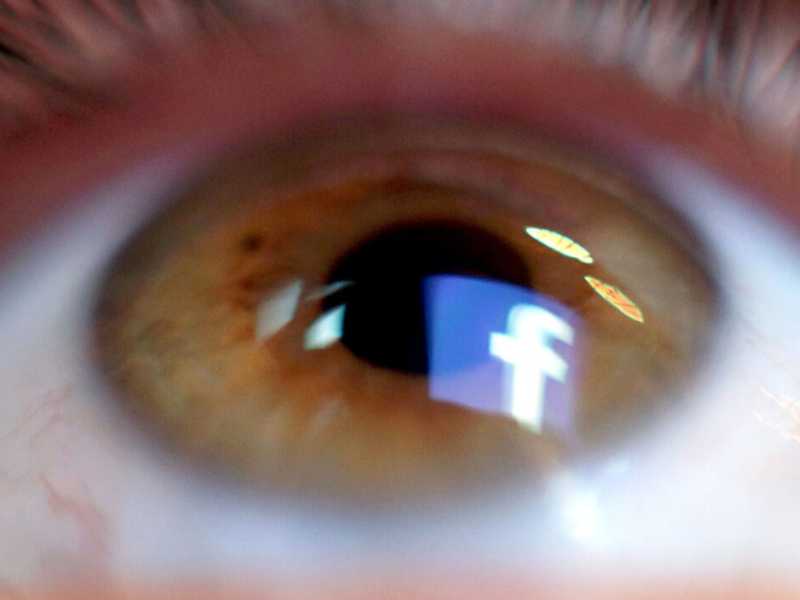 Il logo di Facebook riflesso in un occhio (LaPresse)