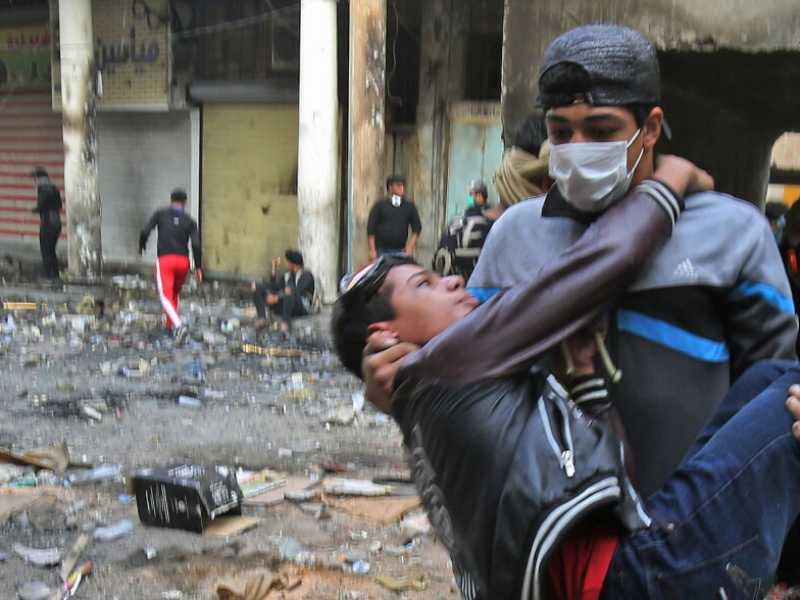 Due manifestanti durante gli scontri con le forze di sicurezza a Baghdad (foto LaPresse)