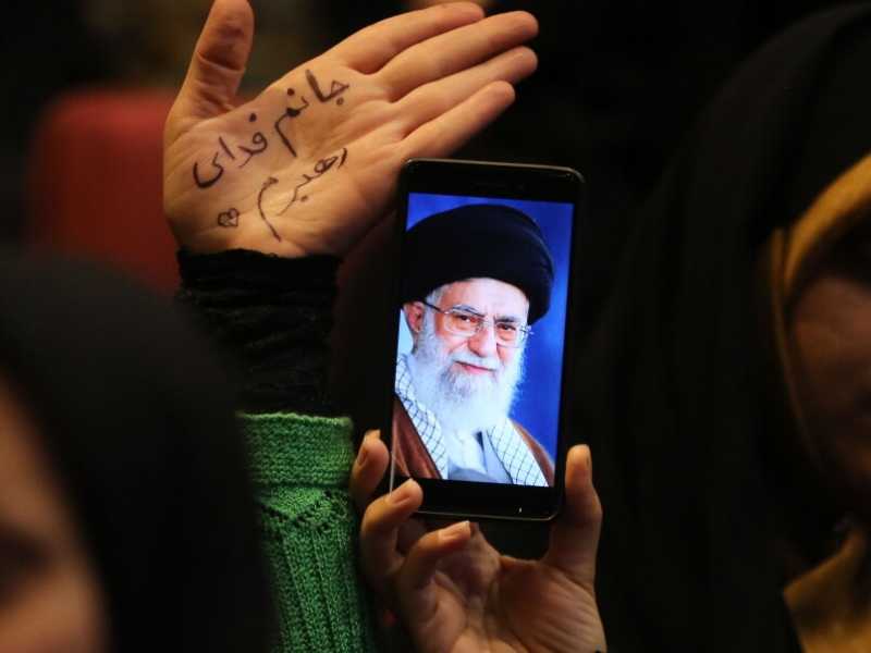 Donne iraniane filo regime mostrano sullo smartphone una foto dell&rsquo;ayatollah Khamenei (Atta Kenare / AFP)