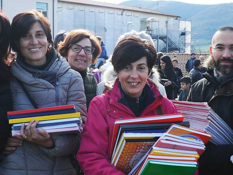 Genitori e insegnanti con i quaderni per i ragazzi durante la riapertura delle scuole a Norcia dopo il terremoto (foto LaPresse)  