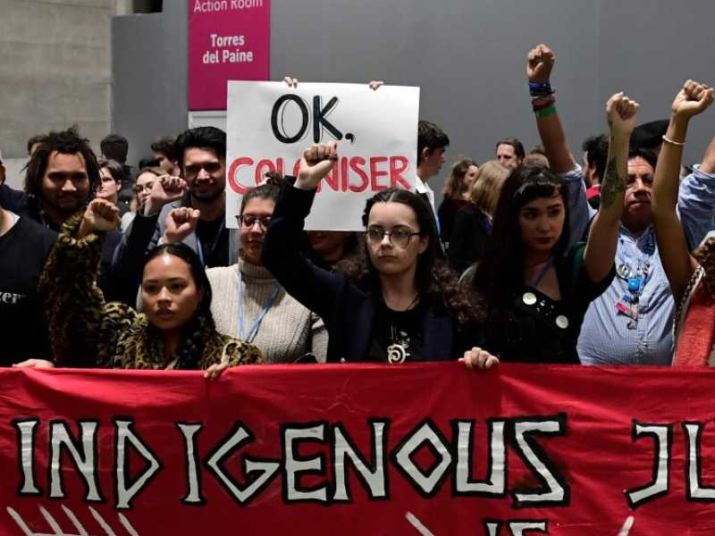 Manifestanti provenienti da comunità indigene prendono parte a una protesta sull'emergenza climatica durante la Cop25 a Madrid (foto LaPresse)