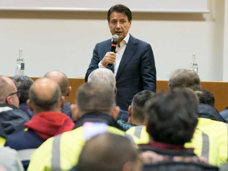 Il premier Giuseppe Conte con gli operai dell'ex Ilva alla vigilia di Natale (foto LaPresse)