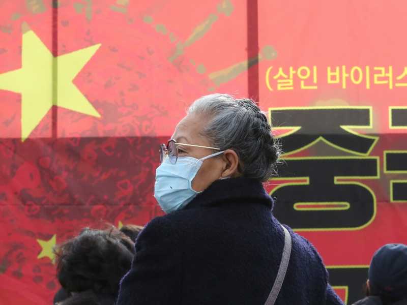 A Seul una donna si unisce a una manifestazione per chiedere al governo sudcoreano di vietare l'ingresso nel paese ai cinesi, per paura del coronavirus (foto LaPresse)