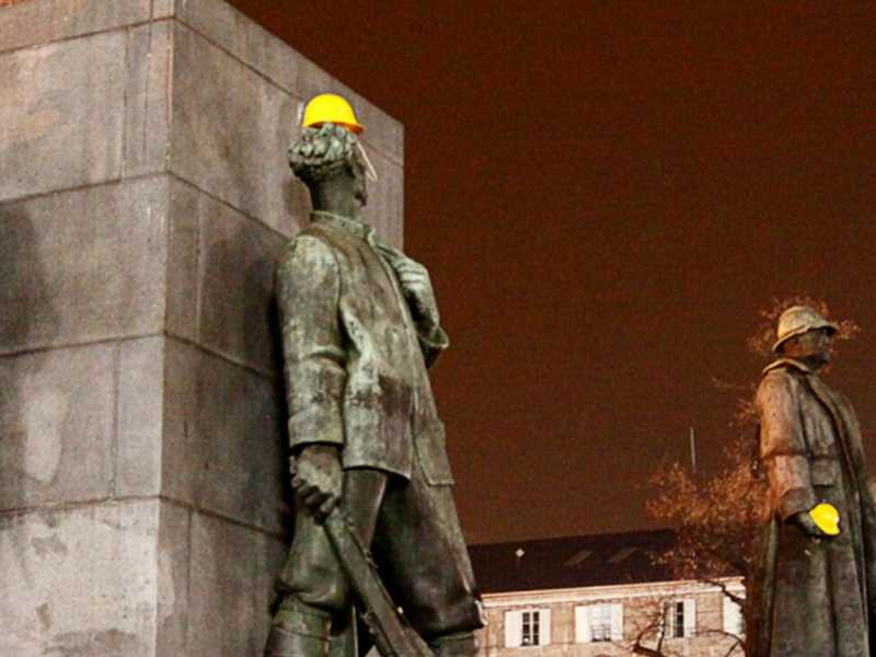 Un elmetto giallo apposto sui monumenti di Torino in ricordo degli operai morti allo stabilimento della Thyssen a Torino (foto LaPresse)