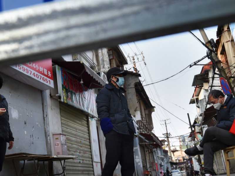 Un volontario su una sedia, di guardia alle barricate che bloccano una zona residenziale di Wuhan nella provincia dello Hubei, nella Cina centrale (Chinatopix via LaPresse)