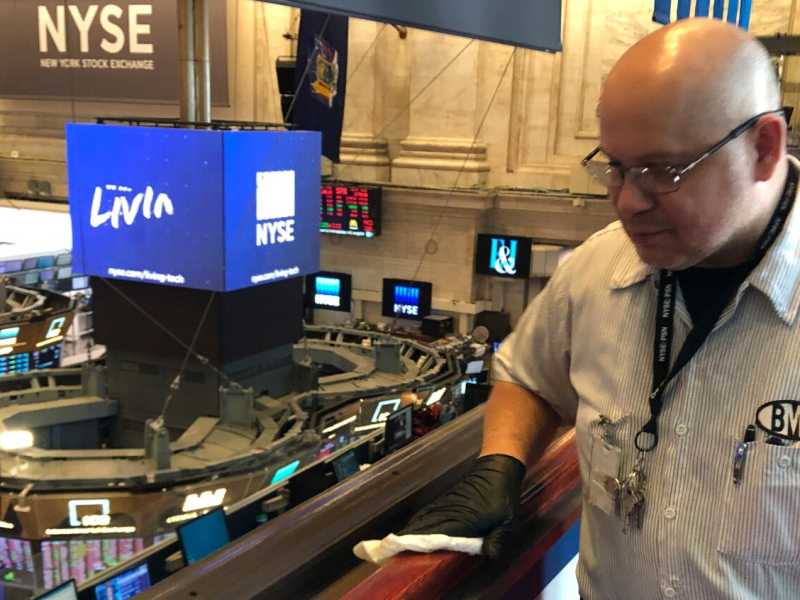 Un inserviente disinfetta i locali dello Stock Exchange di New York (foto LaPresse)