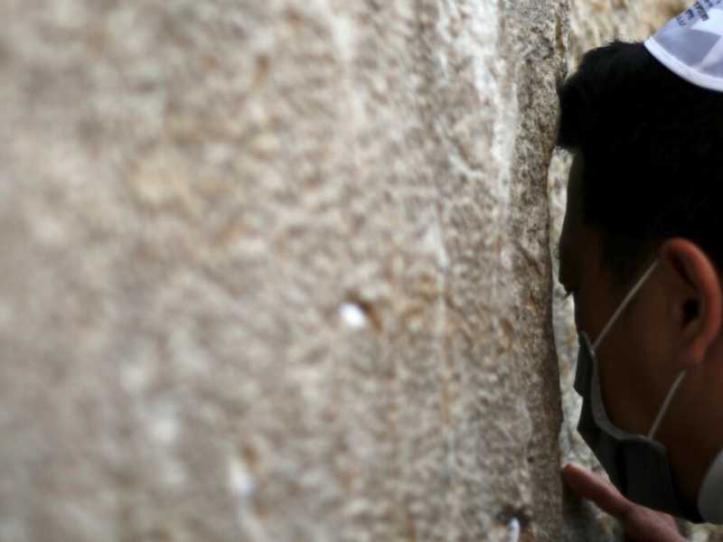 Un uomo con mascherina al Muro del pianto (foto LaPresse)