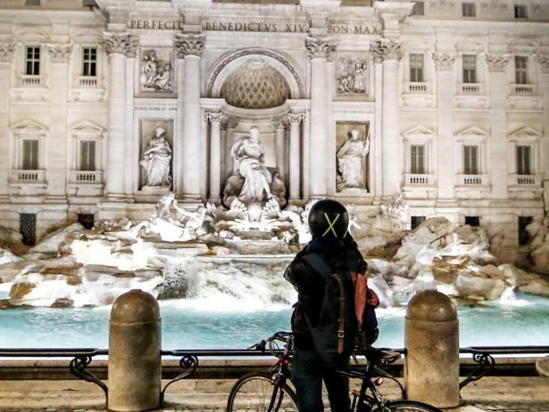 Piazze e strade deserte a Roma. Un passante solitario davanti alla fontana di Trevi (foto LaPresse)