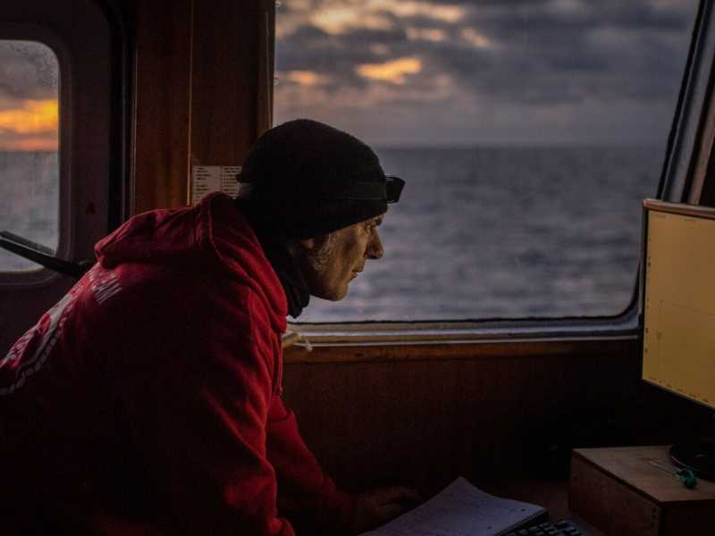 Un membro dell'equipaggio di una nave ong, la Open Arms, in navigazione (foto LaPresse)