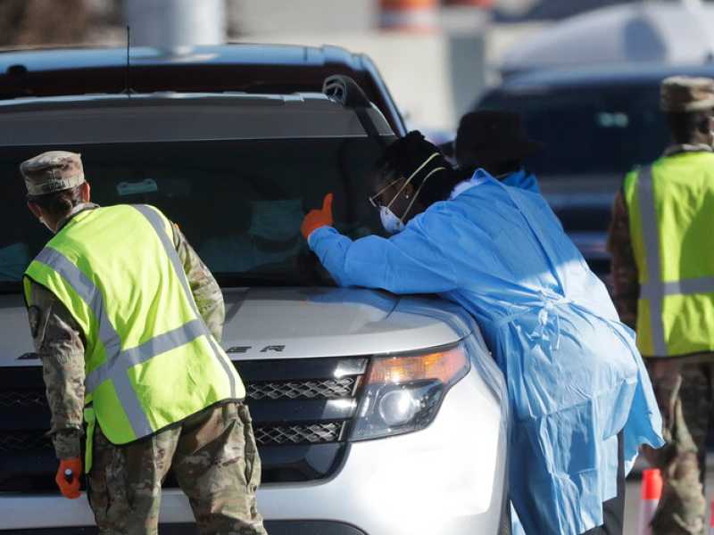 La guardia nazionale della Florida e gli operatori sanitari controllano i passeggeri davanti all'Hard Rock Stadium di Miami (LaPresse)