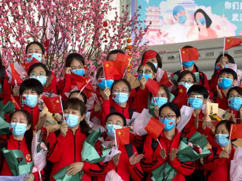 Medici e infermieri all'aeroporto di Wuhan saluta prima di tornare alle rispettive case dopo la fine del lockdown (foto LaPresse)