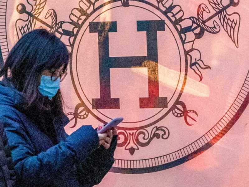 Due persone con mascherina davanti alla vetrina di una boutique di Herm&egrave;s (foto LaPresse)