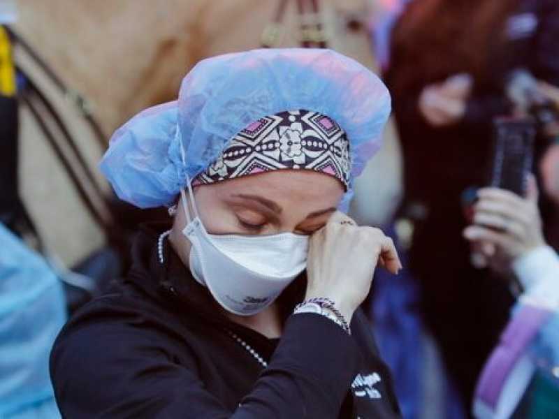 Una giovane operatrice sanitaria di New York mentre viene incoraggiata dalla folla (Frank Franklin II / Ap Photo)
