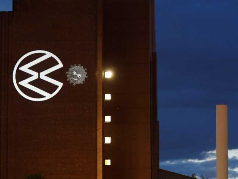 L'immagine proiettata su un muro del quartier generale Volkswagen a Wolfsburg: il logo dell'azienda, in versione Pac-Man, mangia il coronavirus (foto Reuters/Fabian Bimmer)