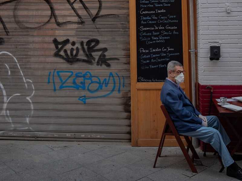 Due clienti all'esterno di un locale di Siviglia (foto LaPresse)