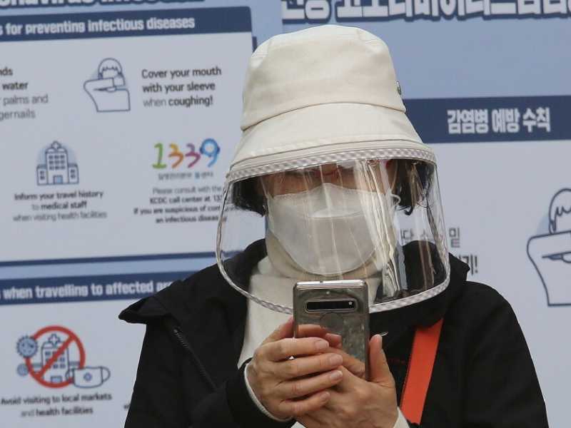 Una donna consulta lo smartphone a Seul, Corea del sud (foto LaPresse)