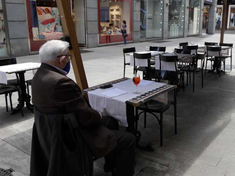 Un uomo seduto da solo in un ristorante di Milano (foto LaPresse)