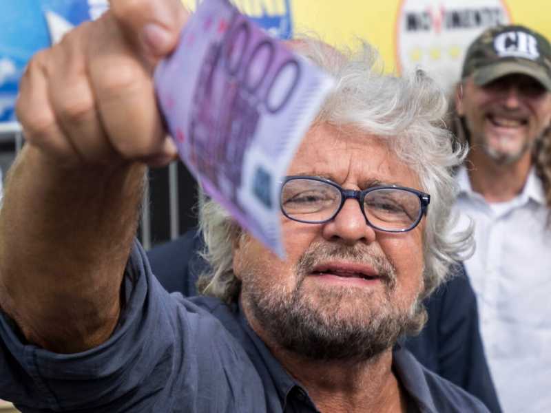 Beppe grillo distribuisce soldi finti ai giornalisti (foto LaPresse)