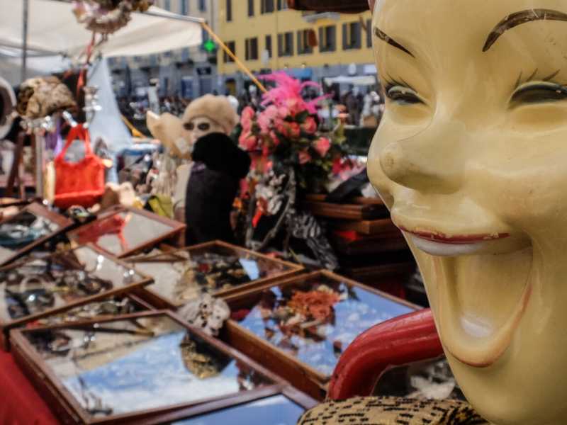 Turisti tra le bancarelle del mercatino dell'antiquariato sul Naviglio Grande di Milano (foto LaPresse)